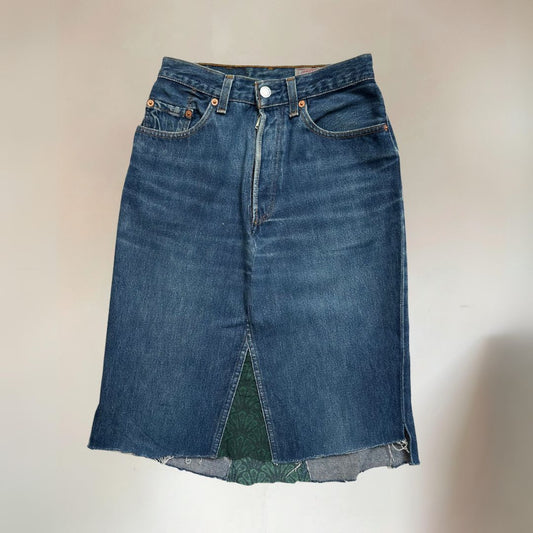 A Levi's denim women's skirt with a knee-length cut, five pockets, and fabric paneling on the end.